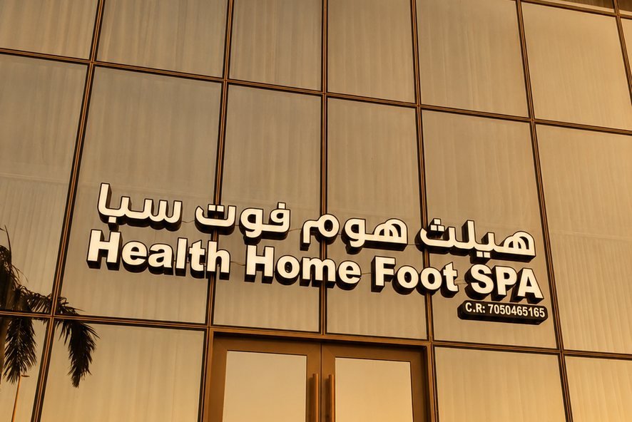 Health Home Foot Spa storefront sign in Al Fayha, Jeddah, at dusk